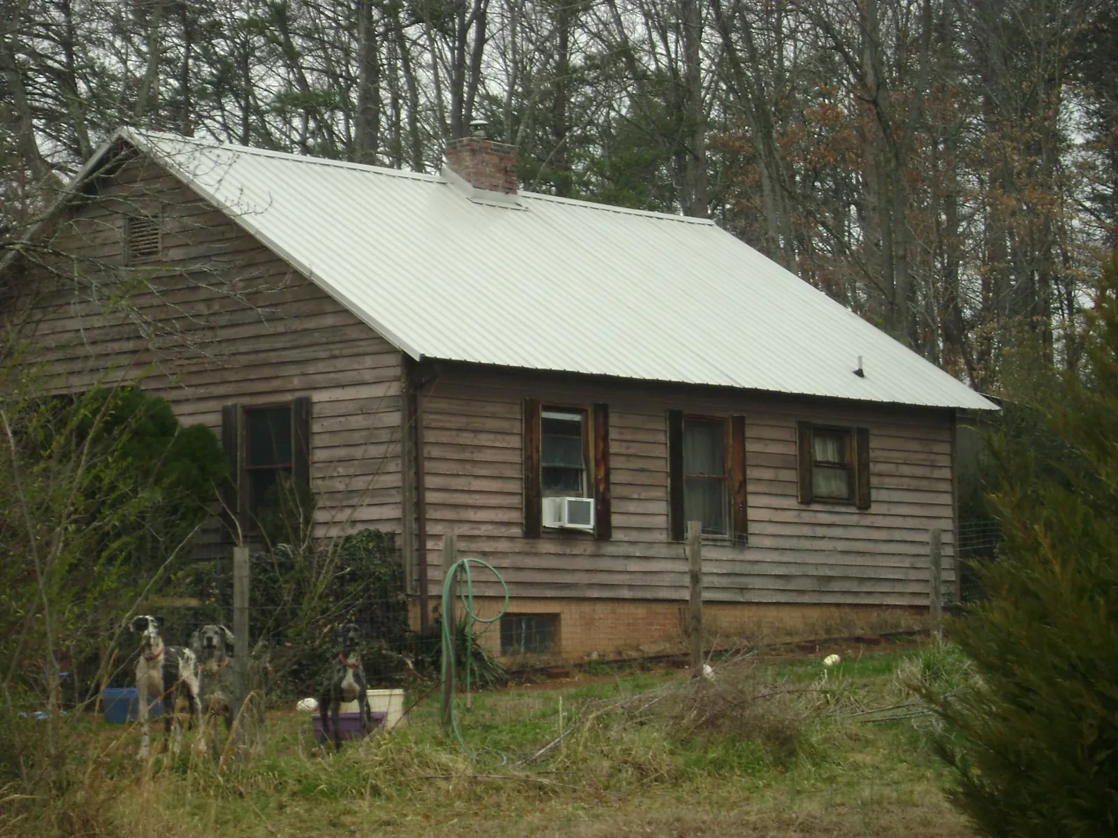 White metal roof on an old wood sided farmhouse, from a Metal Roof Installation job in Ostrander